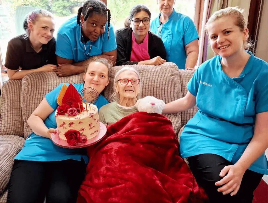 Staff with resident celebrating her birthday with a lovely cake